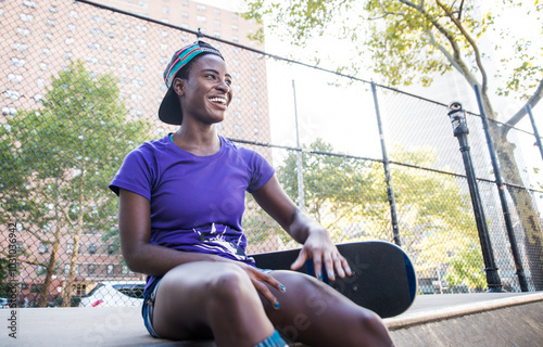 Young girl performing tricks with the skateboard in a skate park