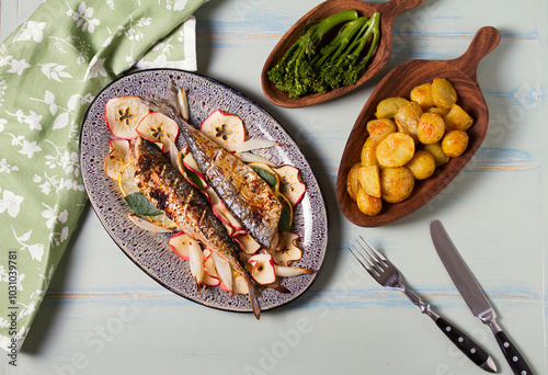 Grilled mackerel with apples, onoions and bay leaves. High angle view photo