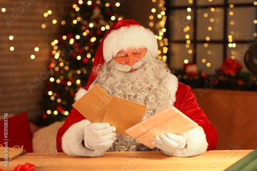 Santa Claus with letters at home on Christmas eve