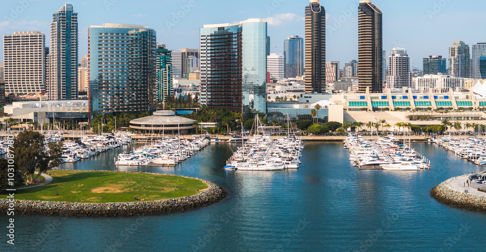 Fototapeta premium Aerial view of San Diego, California, featuring a skyline of high rise buildings, a marina with boats, and the San Diego Convention Center's peaked roofs.