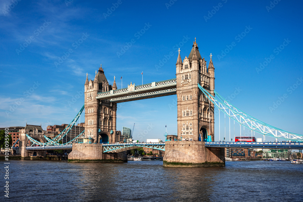 Fototapeta premium Tower Bridge over Thames river famous tourist landmark with cruise in river transportation for travel in center city of London, UK, United Kingdom, British or England in summer with clear blue sky