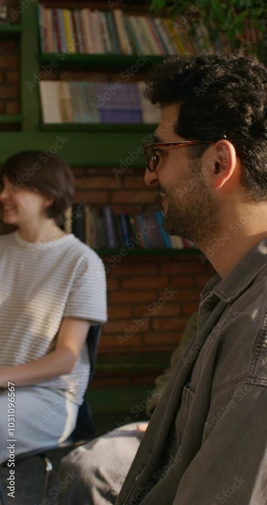 A group of young people are smiling and talking while sitting around a table. They study the Bible together. Daylight A group of young people are smiling and talking while sitting around a table. They study the Bible together. Daylight