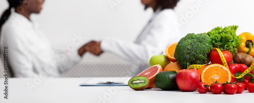 Two black women doctor and patient shaking hands over dietologist workplace photo