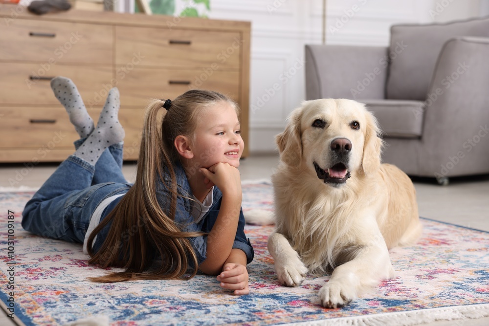 Φωτογραφία Girl with cute Golden Retriever dog lying on rug at home