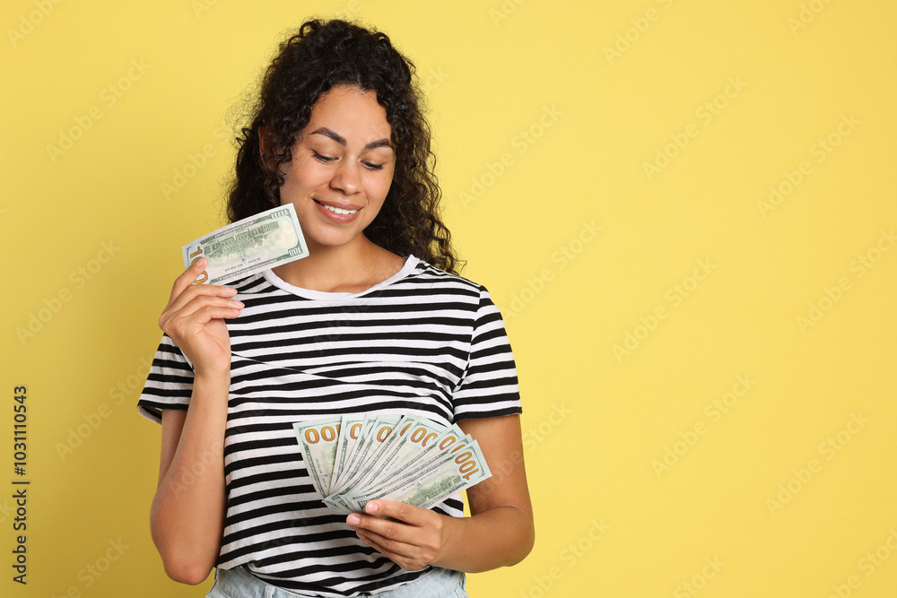 Happy woman with dollar banknotes on yellow background, space for text Happy woman with dollar banknotes on yellow background, space for text