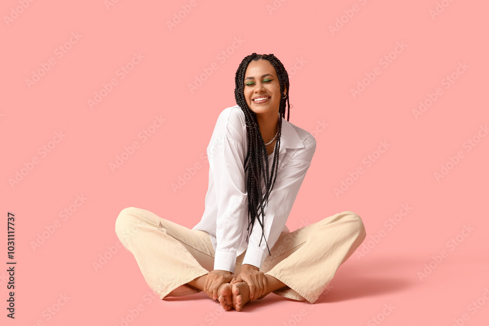 Stylish young African-American woman with braids on pink background Stylish young African-American woman with braids on pink background