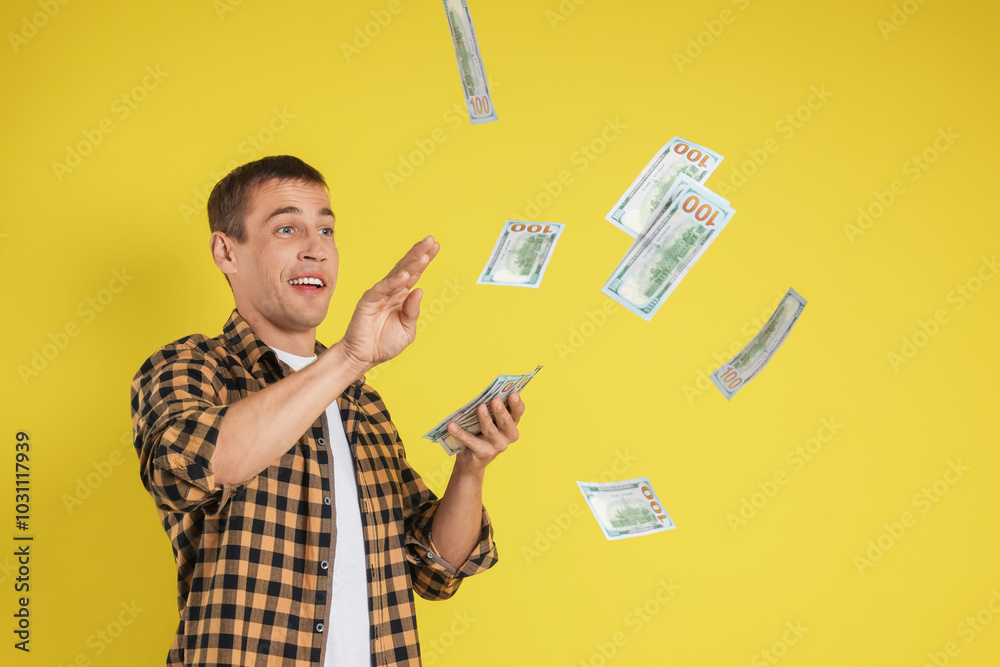 Happy man throwing money on yellow background Happy man throwing money on yellow background