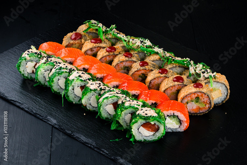 Set of sushi rolls with salmon, tuna, cream cheese, avocado, cucumber and chuka seaweed. photo