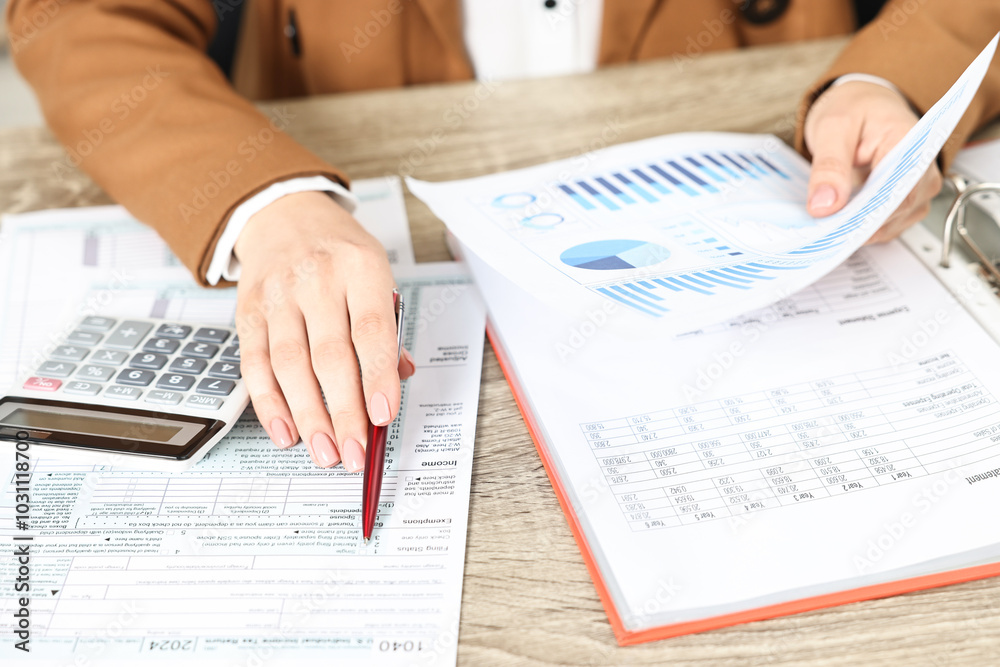Budget planning. Woman with papers and calculator at wooden table, closeup Budget planning. Woman with papers and calculator at wooden table, closeup