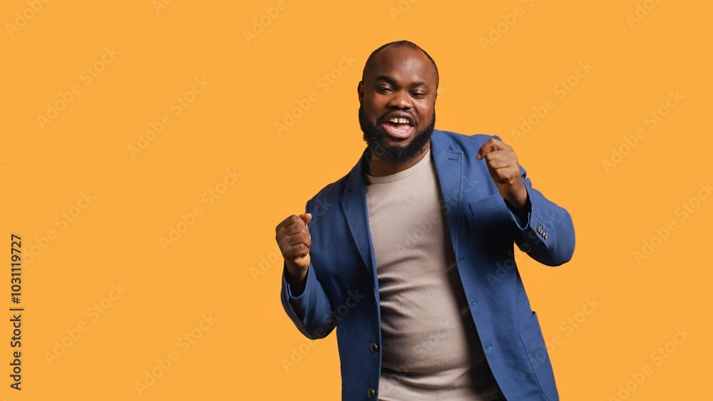 Happy african american person having fun, dancing on rhythm, enjoying leisure time. Cheerful BIPOC man entertaining himself doing funky movements, celebrating achievement, studio background, camera B Happy african american person having fun, dancing on rhythm, enjoying leisure time. Cheerful BIPOC man entertaining himself doing funky movements, celebrating achievement, studio background, camera B