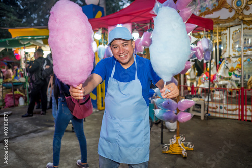 Charismatic seller of pink and light blue cotton candy, he proudly shows his product to visitors.