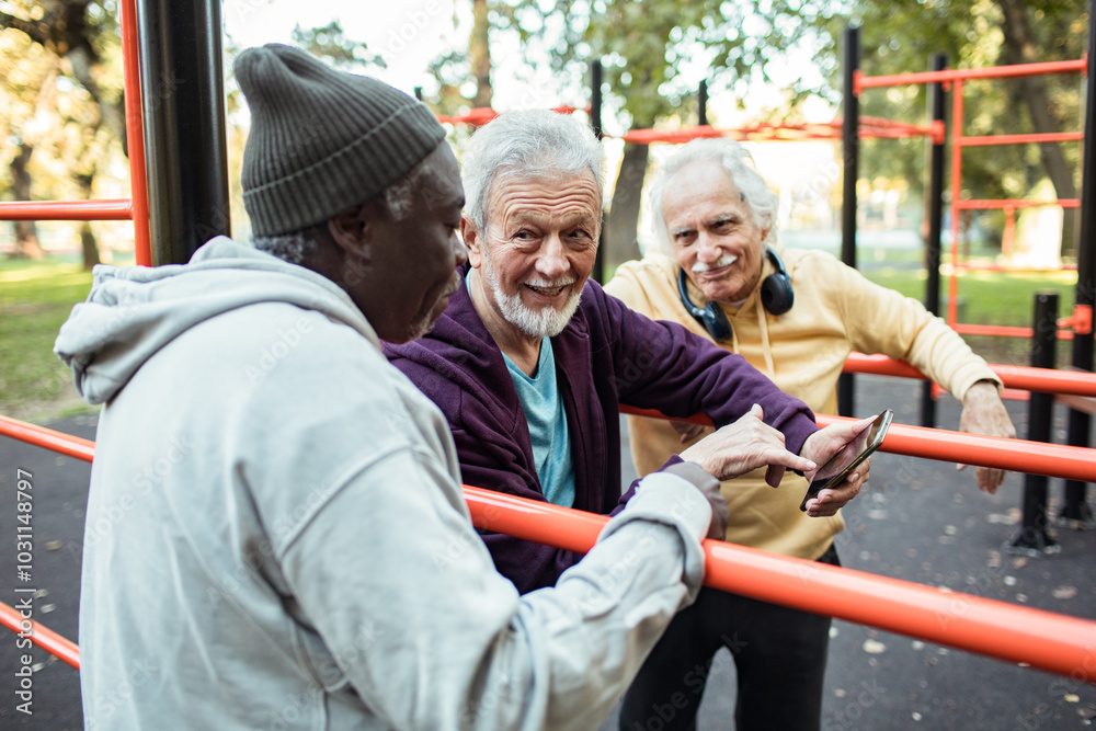 Senior friends using smartphone at outdoor exercise park Senior friends using smartphone at outdoor exercise park