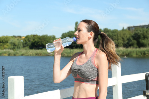 Woman drinking tasty soda water outdoors on sunny day