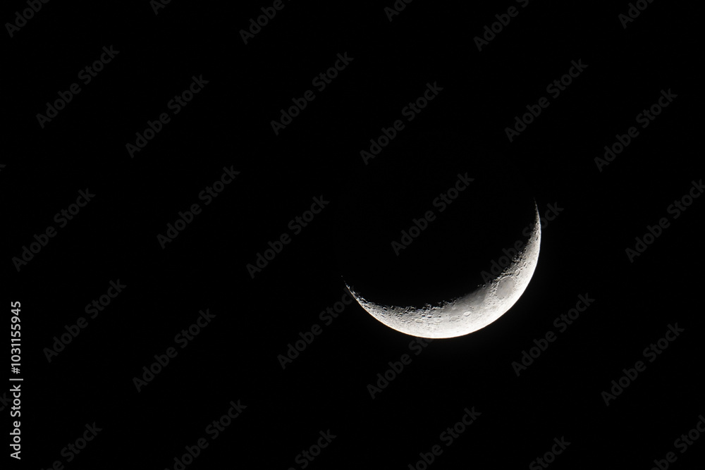Waning crescent moon against black starless and cloudless sky. Waning crescent moon against black starless and cloudless sky.