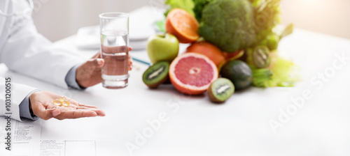 Cropped of afro woman nutritionist giving pills and glass of water to female patient, food supplements concept photo