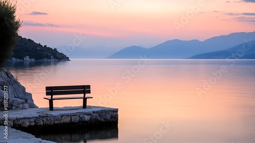 A solitary bench overlooking a calm lake at sunrise