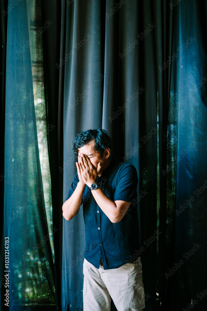 A Southeast Asian man is sneezing, capturing the moment of surprise on his face A Southeast Asian man is sneezing, capturing the moment of surprise on his face