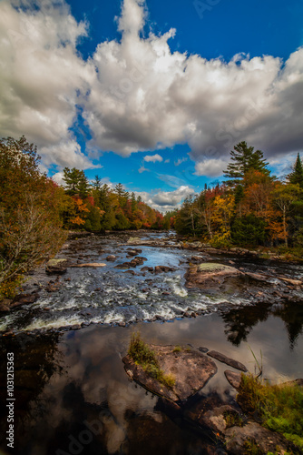 Raquette River Long Lake NY ADK surrounded by brilliant fall foliage on a partly cloudy day photo