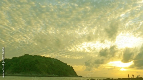 Beautiful sunset n colorful golden yellow cloud or cloudscape on briht sky with silhouette couple take photo or vdo on island rock beach in tropical summer sunlight n sun ray, Slow motion 4k TimeLapse photo