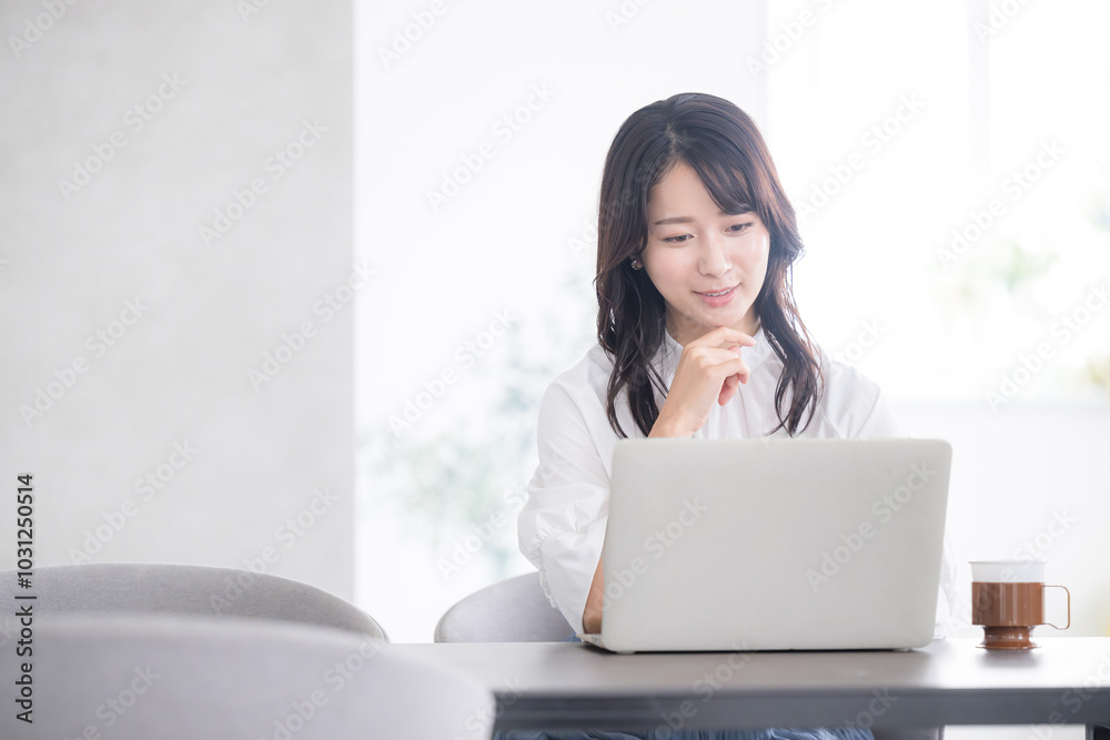 パソコンを見ながら笑顔で悩む若い女性 転職や勉強など若いかわいい女性のイメージ パソコンを見ながら笑顔で悩む若い女性 転職や勉強など若いかわいい女性のイメージ