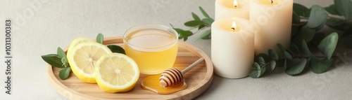 Herbal tea with lemon slices and honey on a bamboo tray, next to soft candles and greenery