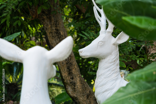 A White Deer Statue in a Lush Green Setting