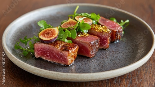 A beautifully plated dish featuring succulent seared meat garnished with fresh figs and greens on a sleek gray plate.