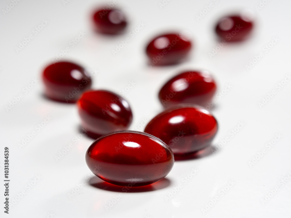 Krill oil capsules on white background. Translucent red softgel capsules of antarctic krill oil. Cardiovascular health. Nutritional supplement with valuable substances Krill oil capsules on white background. Translucent red softgel capsules of antarctic krill oil. Cardiovascular health. Nutritional supplement with valuable substances