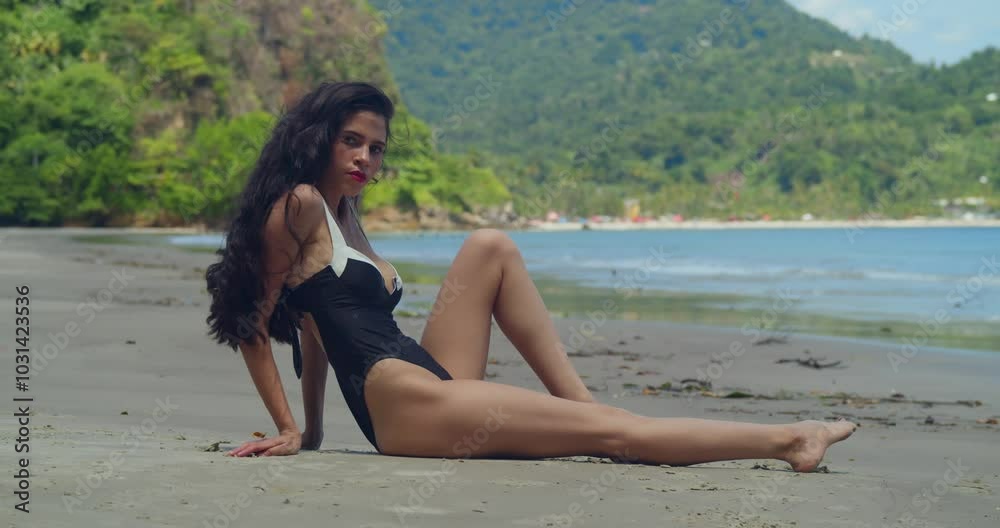 A young Latina girl relaxes in a bikini on a beautiful Caribbean beach. A young Latina girl relaxes in a bikini on a beautiful Caribbean beach.