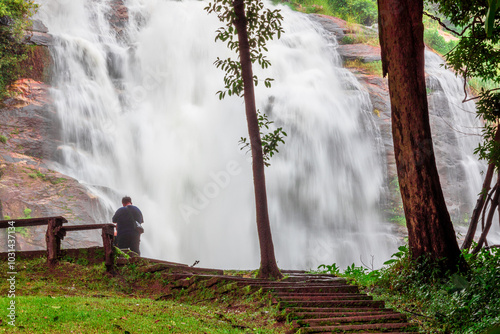 Natural blurred background of waterfalls, fast-flowing currents and water droplets from the wind blowing among the rocks and surrounded by big trees, spontaneous beauty photo