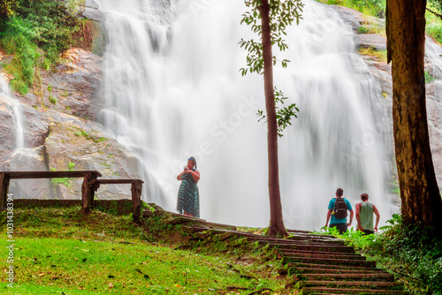 Natural blurred background of waterfalls, fast-flowing currents and water droplets from the wind blowing among the rocks and surrounded by big trees, spontaneous beauty