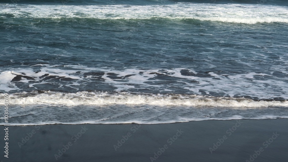 Waves crashing against the shore with a clear blue sky in the background at Parangtritis Beach, Yogyakarta. Waves crashing against the shore with a clear blue sky in the background at Parangtritis Beach, Yogyakarta.