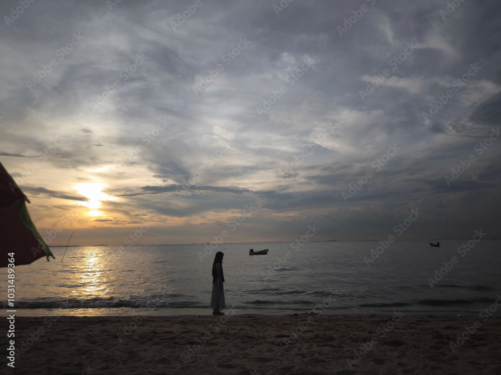Beach during sunset, evening dream, dark sky showing people relaxing Beach during sunset, evening dream, dark sky showing people relaxing