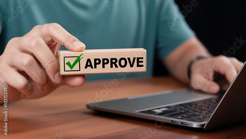 Approved. Businessman holding wooden block with text approve for document approval, assessment, approve the loan, finance agreement, loan, stamp, business. Certified
