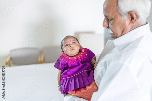 Canvas Print ndian family spending time together, wearing traditional and casual outfits with a baby, a young girl, and grandparents in a high-rise apartment in Kuala Lumpur, Malaysia