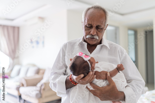 ndian family spending time together, wearing traditional and casual outfits with a baby, a young girl, and grandparents in a high-rise apartment in Kuala Lumpur, Malaysia. photo