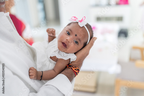 Photography ndian family spending time together, wearing traditional and casual outfits with a baby, a young girl, and grandparents in a high-rise apartment in Kuala Lumpur, Malaysia