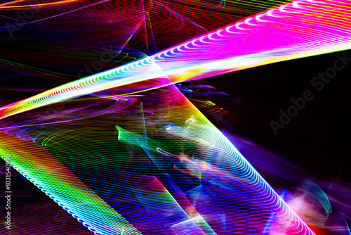 A colorful, abstract image with a rainbow of colors and a black background. The image is a representation of a light show or a colorful pattern