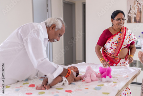 Photography ndian family spending time together, wearing traditional and casual outfits with a baby, a young girl, and grandparents in a high-rise apartment in Kuala Lumpur, Malaysia