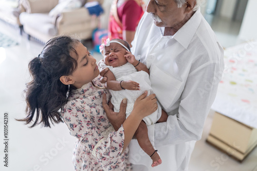 Photography ndian family spending time together, wearing traditional and casual outfits with a baby, a young girl, and grandparents in a high-rise apartment in Kuala Lumpur, Malaysia