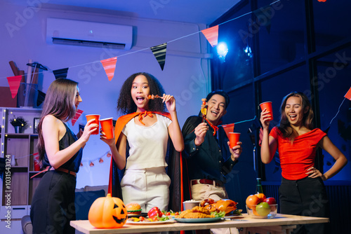 Joyful friends in vibrant Halloween costumes share drinks and laughter at a festive indoor party. photo