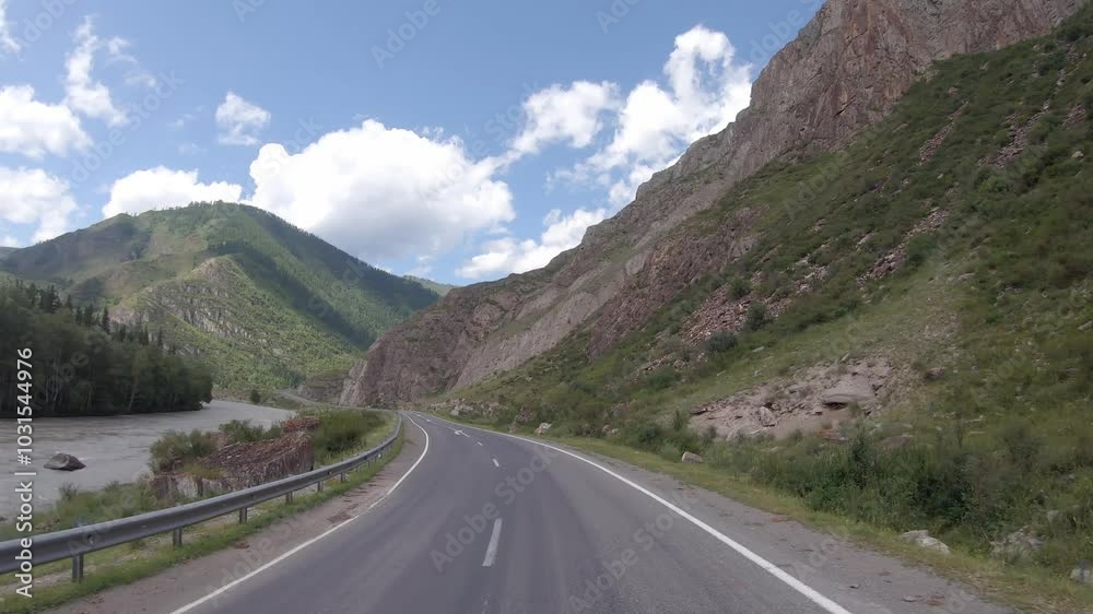 Driving in a car along the mountain road of the Chuya Highway or the Chuysky Trakt in Altai. Siberia, Russia Driving in a car along the mountain road of the Chuya Highway or the Chuysky Trakt in Altai. Siberia, Russia