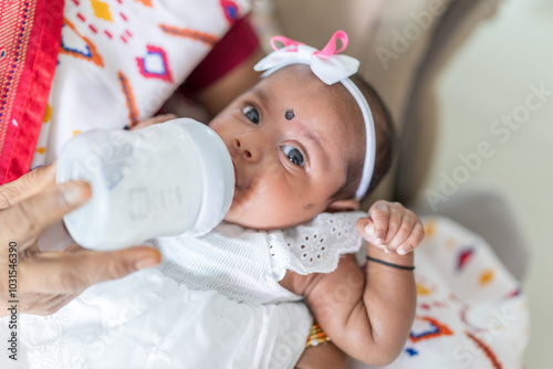 ndian family spending time together, wearing traditional and casual outfits with a baby, a young girl, and grandparents in a high-rise apartment in Kuala Lumpur, Malaysia. photo