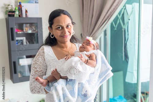 ndian family spending time together, wearing traditional and casual outfits with a baby, a young girl, and grandparents in a high-rise apartment in Kuala Lumpur, Malaysia. photo