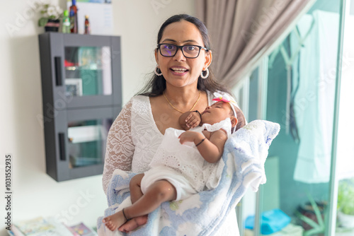 ndian family spending time together, wearing traditional and casual outfits with a baby, a young girl, and grandparents in a high-rise apartment in Kuala Lumpur, Malaysia. photo