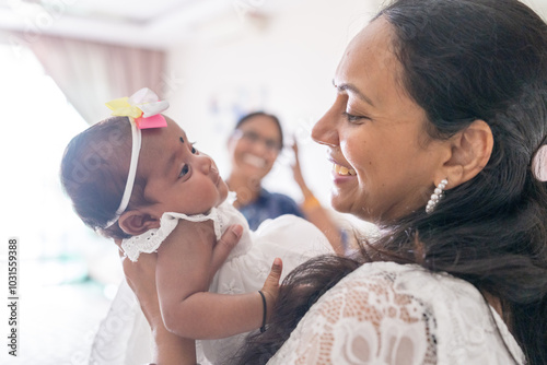 ndian family spending time together, wearing traditional and casual outfits with a baby, a young girl, and grandparents in a high-rise apartment in Kuala Lumpur, Malaysia. photo