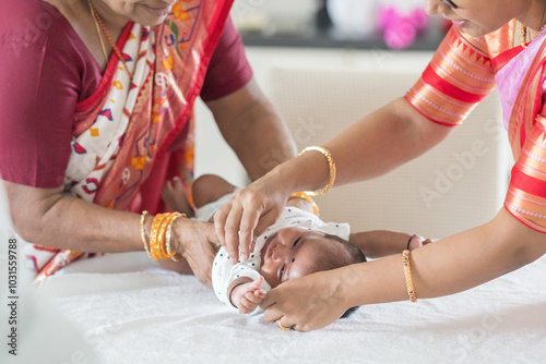 ndian family spending time together, wearing traditional and casual outfits with a baby, a young girl, and grandparents in a high-rise apartment in Kuala Lumpur, Malaysia. photo