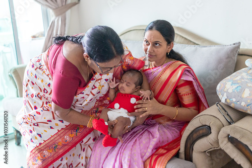 ndian family spending time together, wearing traditional and casual outfits with a baby, a young girl, and grandparents in a high-rise apartment in Kuala Lumpur, Malaysia. photo