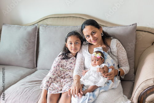 ndian family spending time together, wearing traditional and casual outfits with a baby, a young girl, and grandparents in a high-rise apartment in Kuala Lumpur, Malaysia. photo