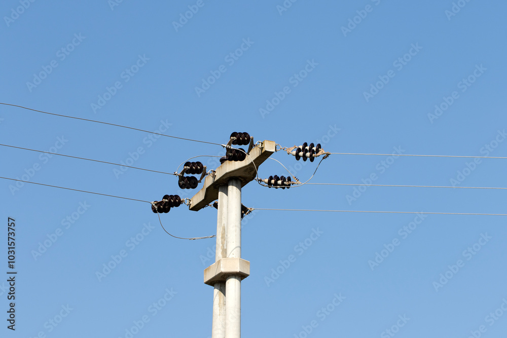 A concrete pole on an electricity transmission line on blue sky background A concrete pole on an electricity transmission line on blue sky background